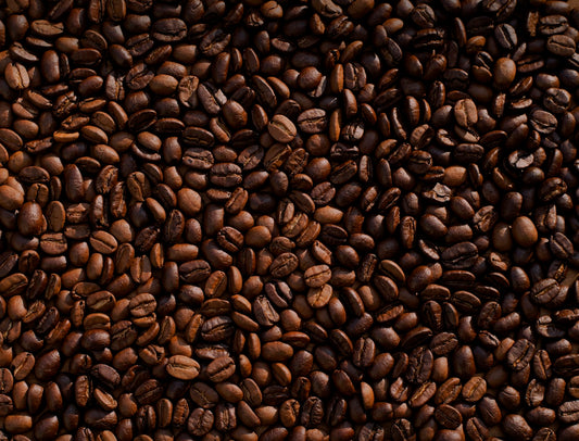 Freshly roasted whole coffee beans stored in an airtight ceramic canister on a wooden kitchen shelf
