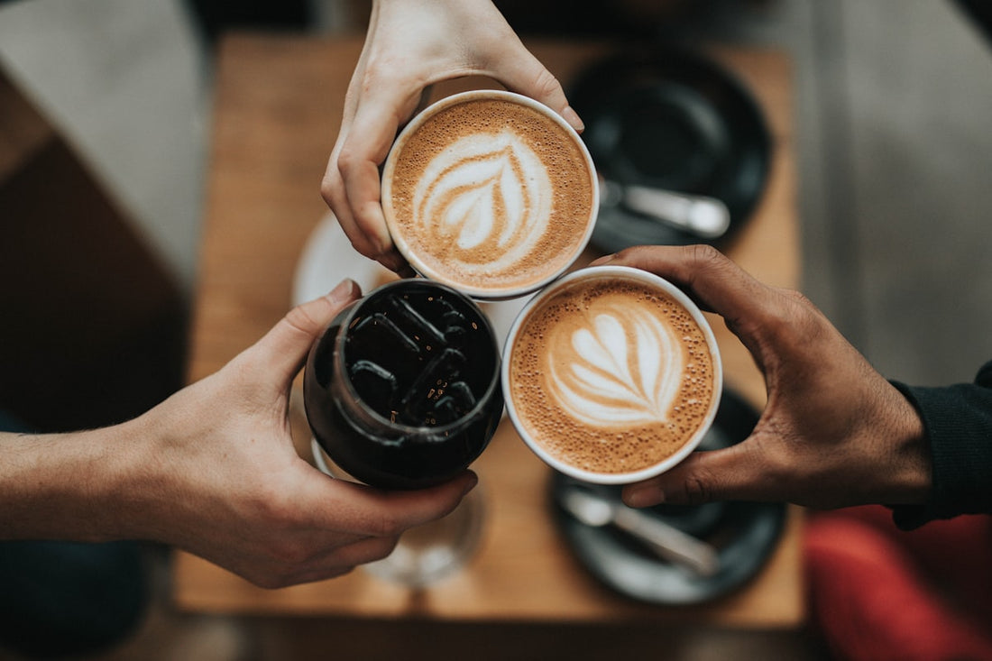 Beginner's guide to specialty coffee — a warm cup of freshly brewed coffee on a wooden table with coffee beans scattered nearby