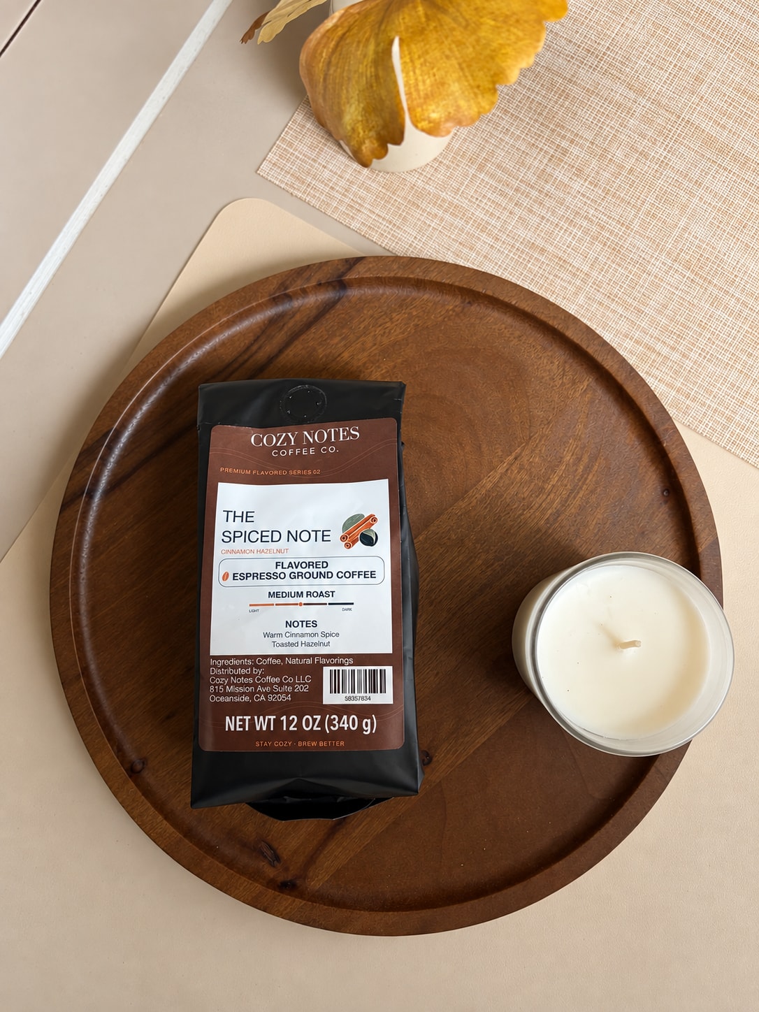 The Spiced Note cinnamon-hazelnut medium-roast coffee bag beside a candle on Will’s wooden kitchen tray.