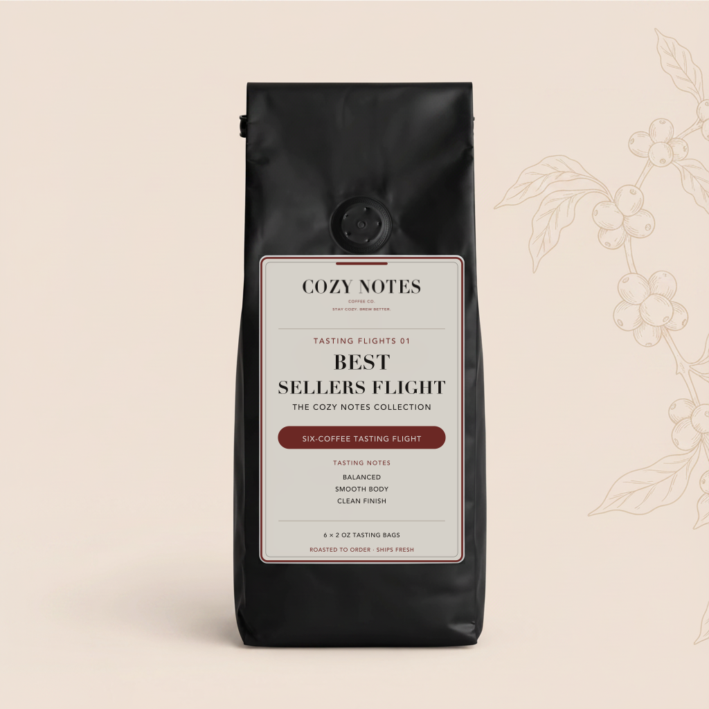 A black bag of Cozy Notes Best Sellers Flight six-coffee tasting flight, featuring a cream and burgundy label, set against a light beige background with a delicate coffee plant illustration.