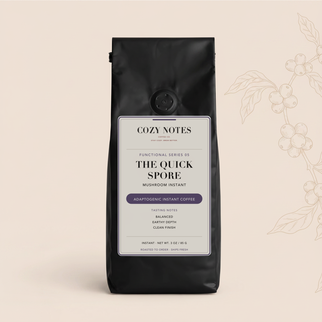 A black stand-up coffee bag with a white and purple label reading Cozy Notes The Quick Spore mushroom instant, centered on a warm beige background with faint coffee branch line art at the right.
