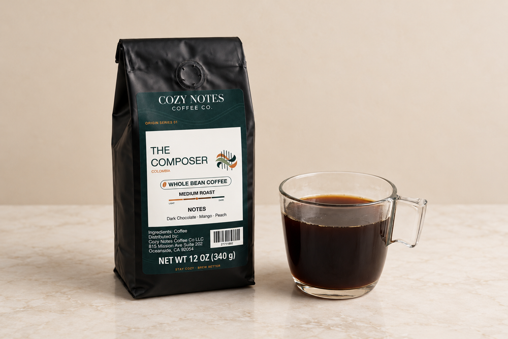 The Composer coffee bag beside a clear glass mug of black coffee.