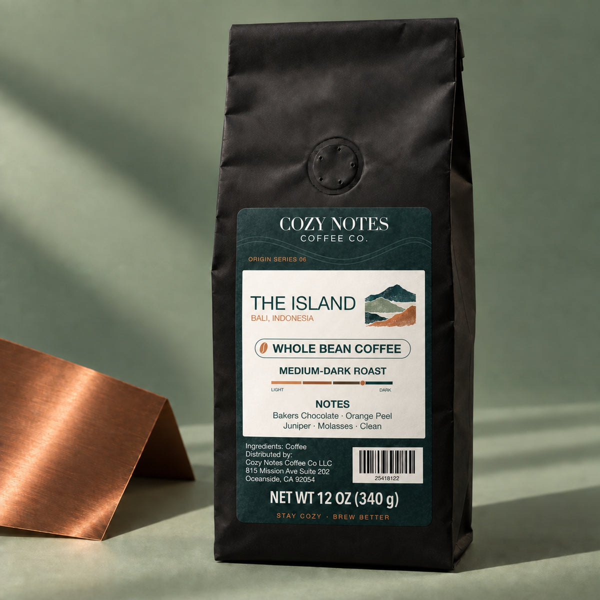 The Island Bali medium-dark roast coffee, whole bean, 12 oz — editorial view with Cozy Notes mountain label.