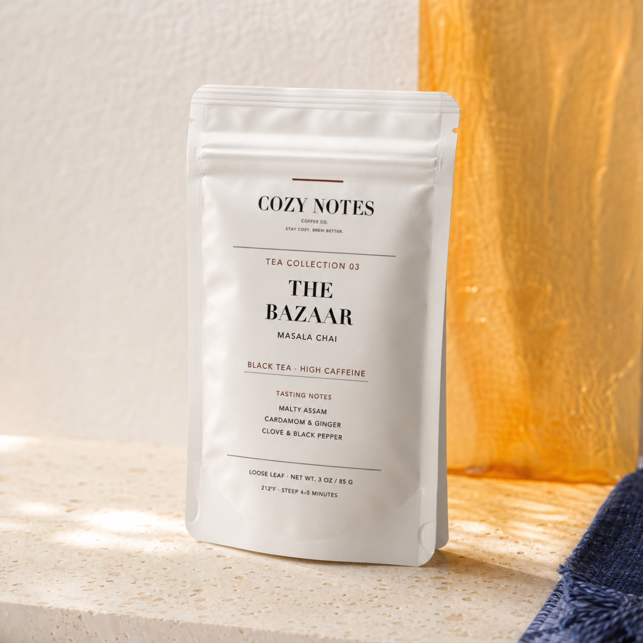 Cozy Notes The Bazaar masala chai pouch in a bright saffron and indigo editorial setting