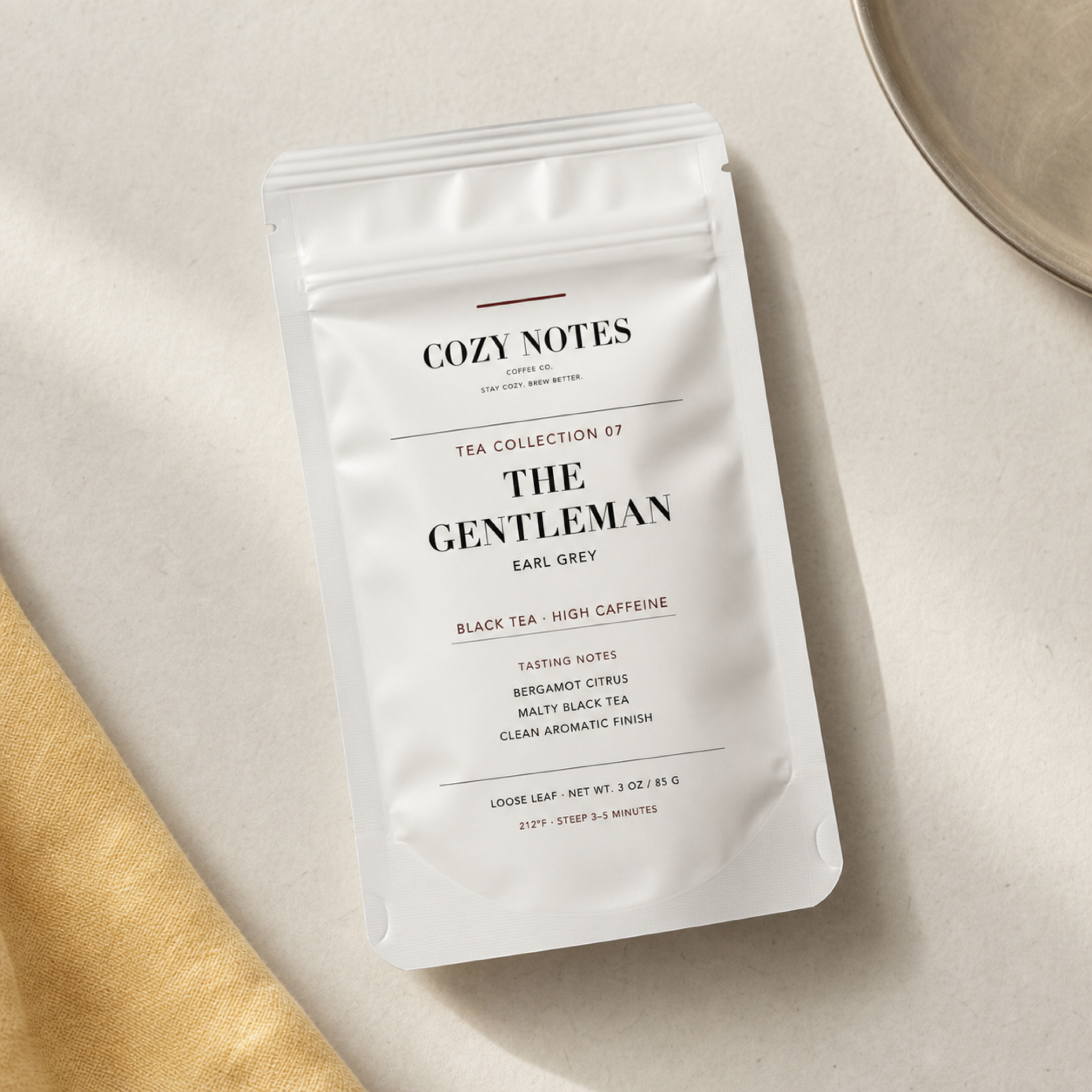 Overhead view of Cozy Notes The Gentleman Earl Grey pouch on warm gray and butter linen