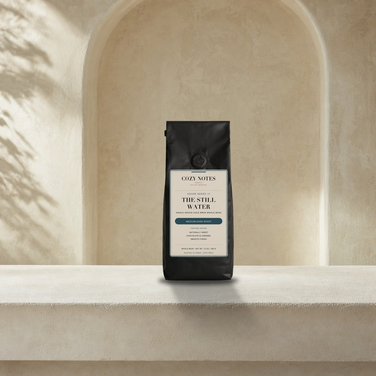 The Still Water — Single Origin Cold Brew Whole Bean Coffee, Medium-Dark Roast — 12 oz Cozy Notes bag on a kitchen counter, roasted to order