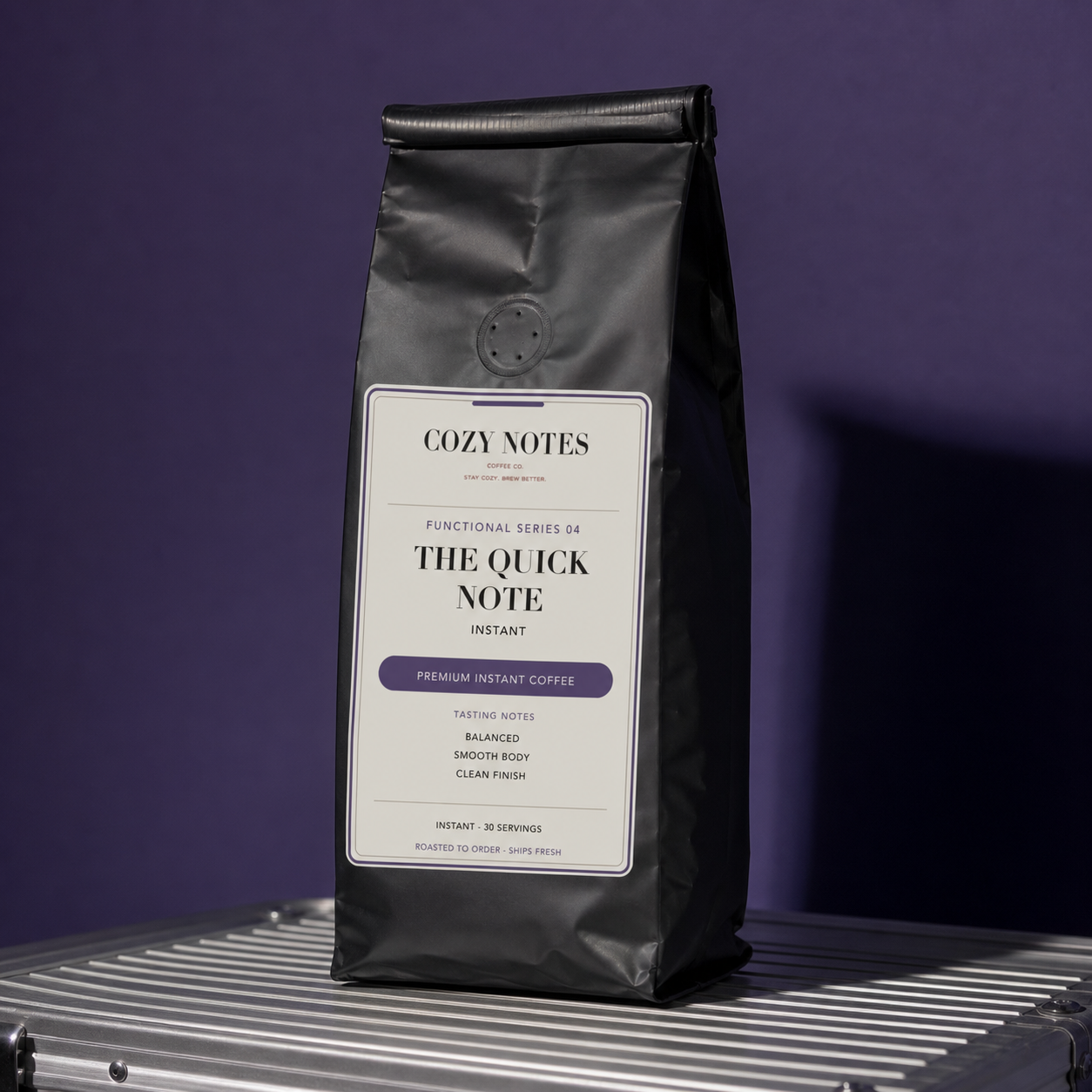 A black stand-up coffee bag labeled Cozy Notes The Quick Note Instant, photographed upright on a metallic surface against a dark purple background.